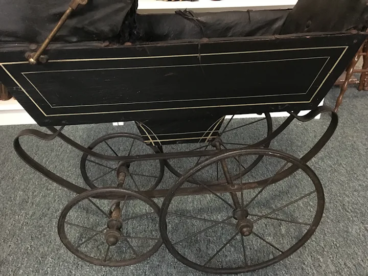 Circa late 1800s Black Wood, Metal, and Leather Doll Buggy. For